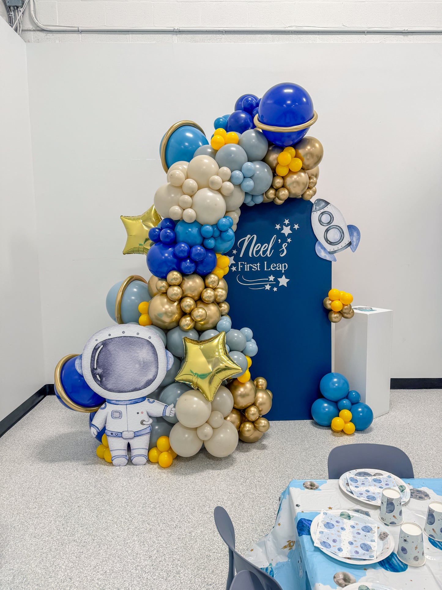 Large solid astronaut themed balloon display with foils and cake stand