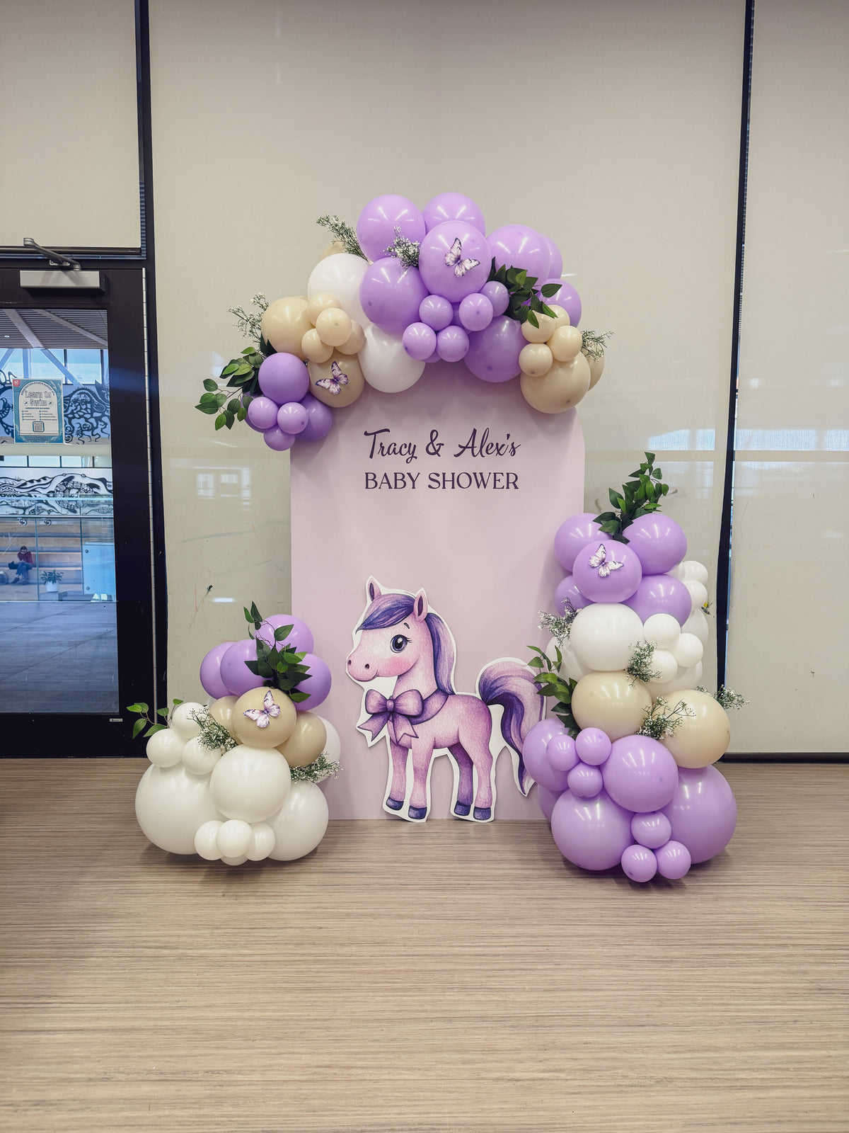 Large solid backdrop with balloons, greenery and prop cutout