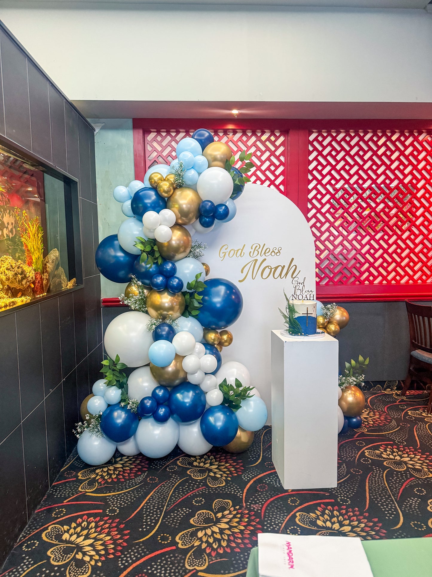Large solid backdrop with lush balloons, floral accents and cake stand