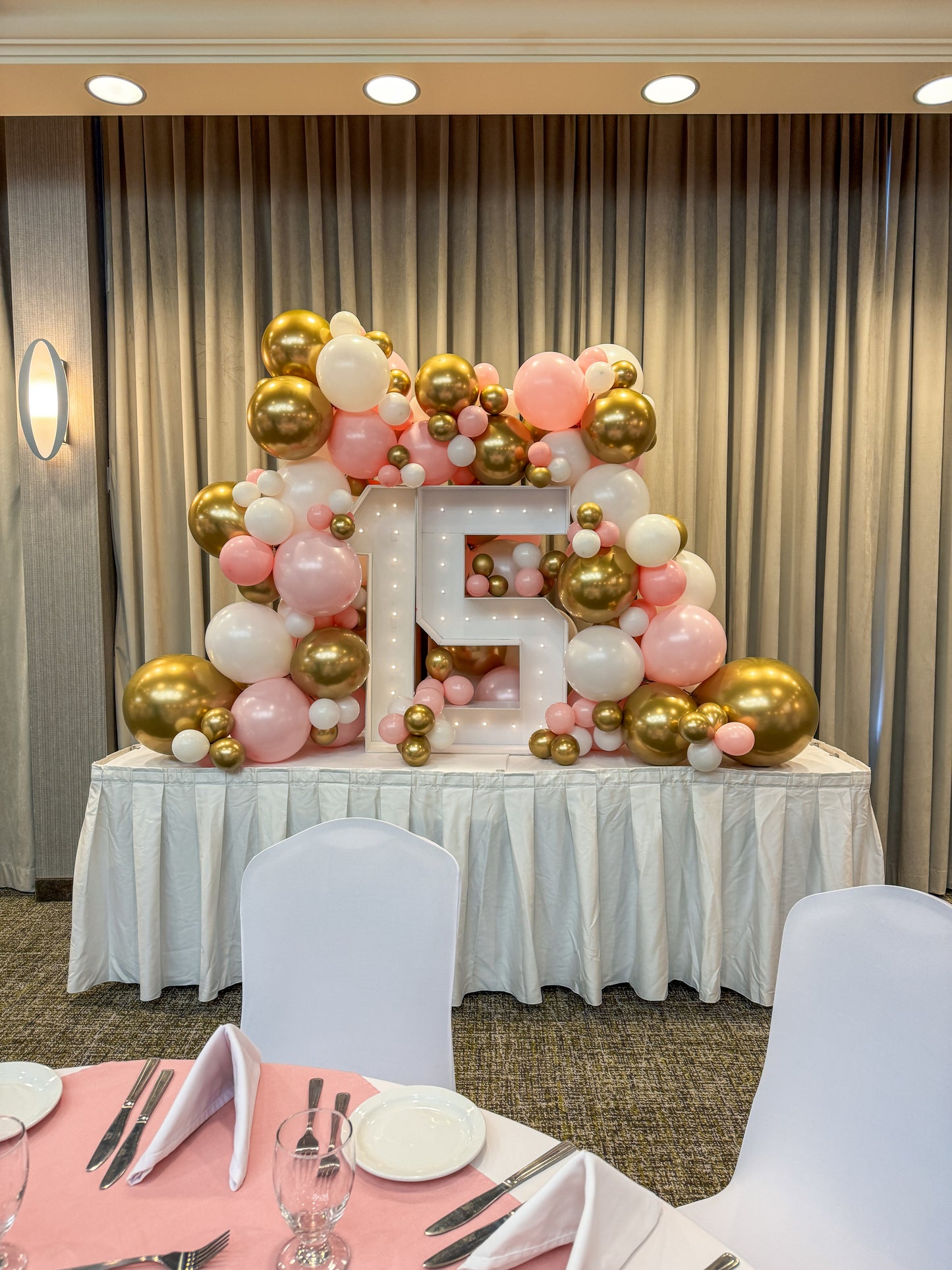 Marquee numbers with 8 feet worth of balloons on a table