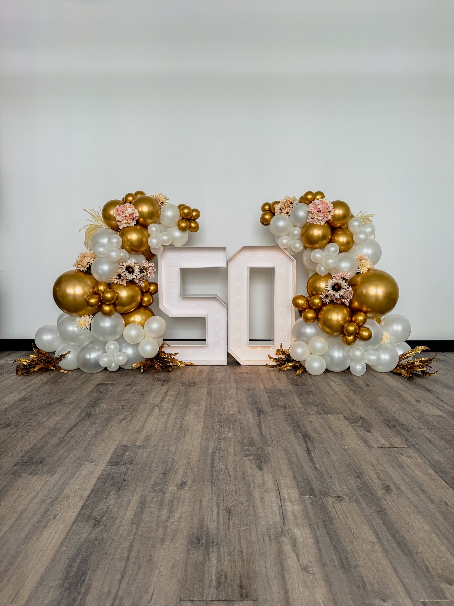 Two light up numbers with side balloon garlands and floral accents