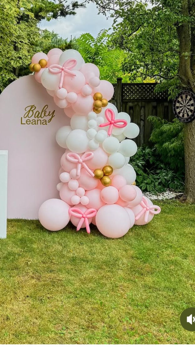 Large solid backdrop with lush side balloons and bows.
