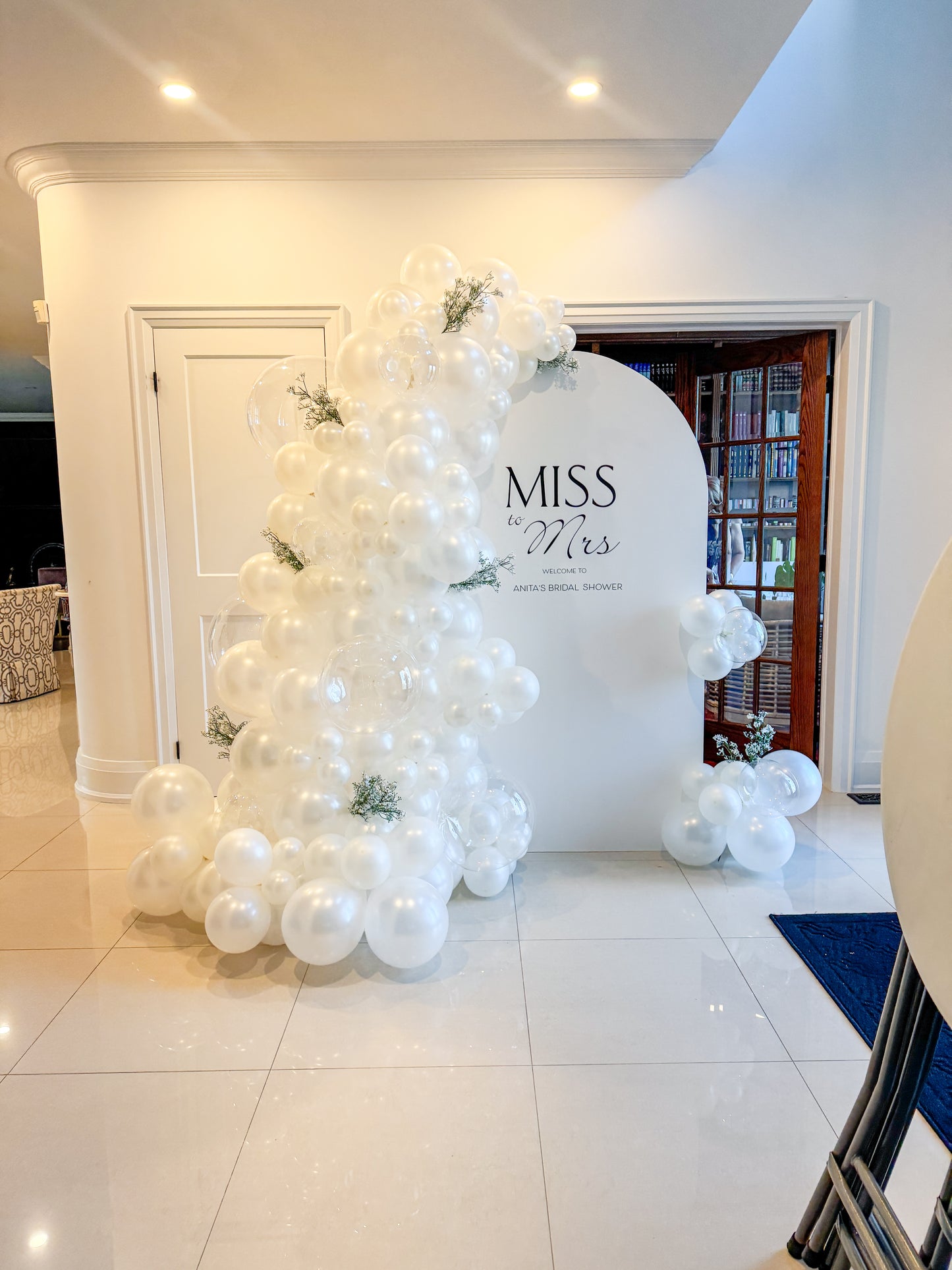 Large white solid pearl balloons backdrop with baby’s breath and clear bobo balloons