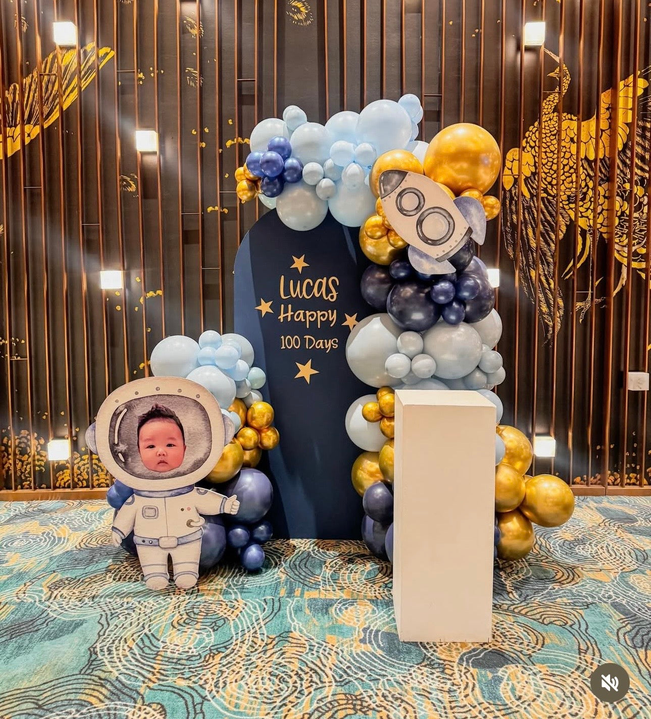 Middle solid astronaut themed balloon backdrop with a personalized face photo and cake stand