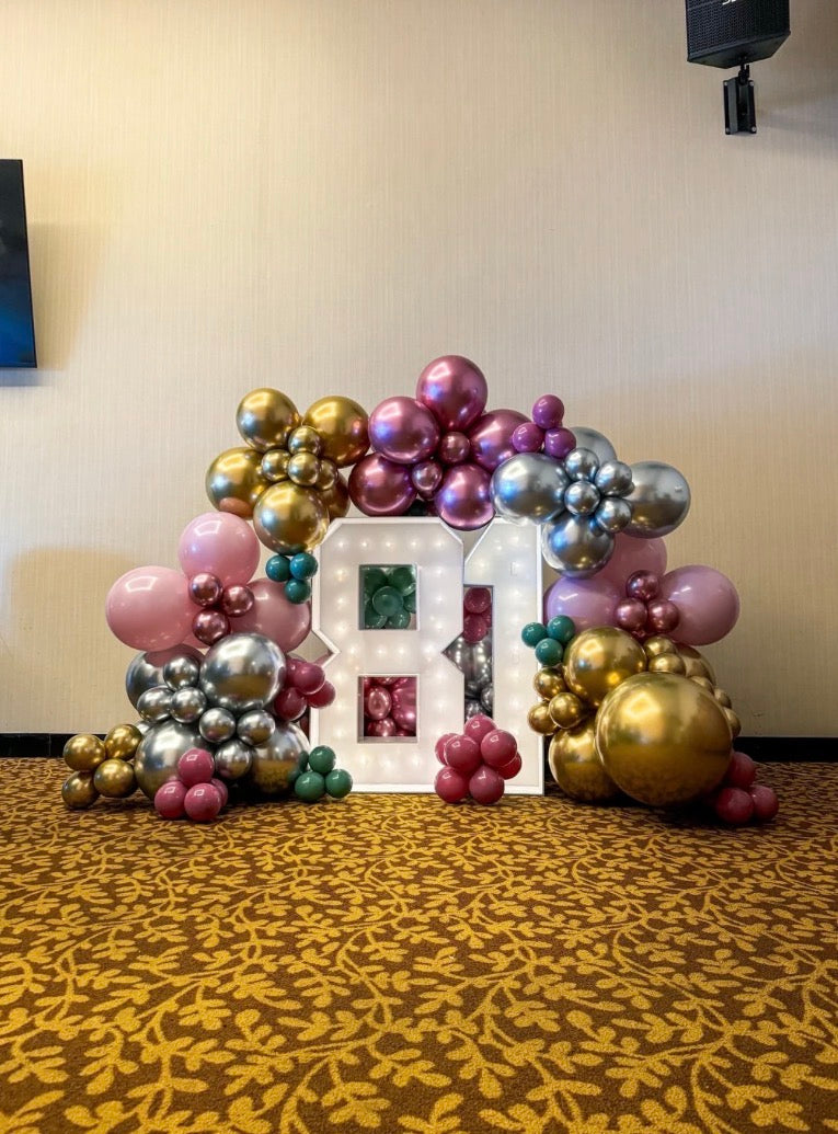 Two light up numbers surrounding balloon garland