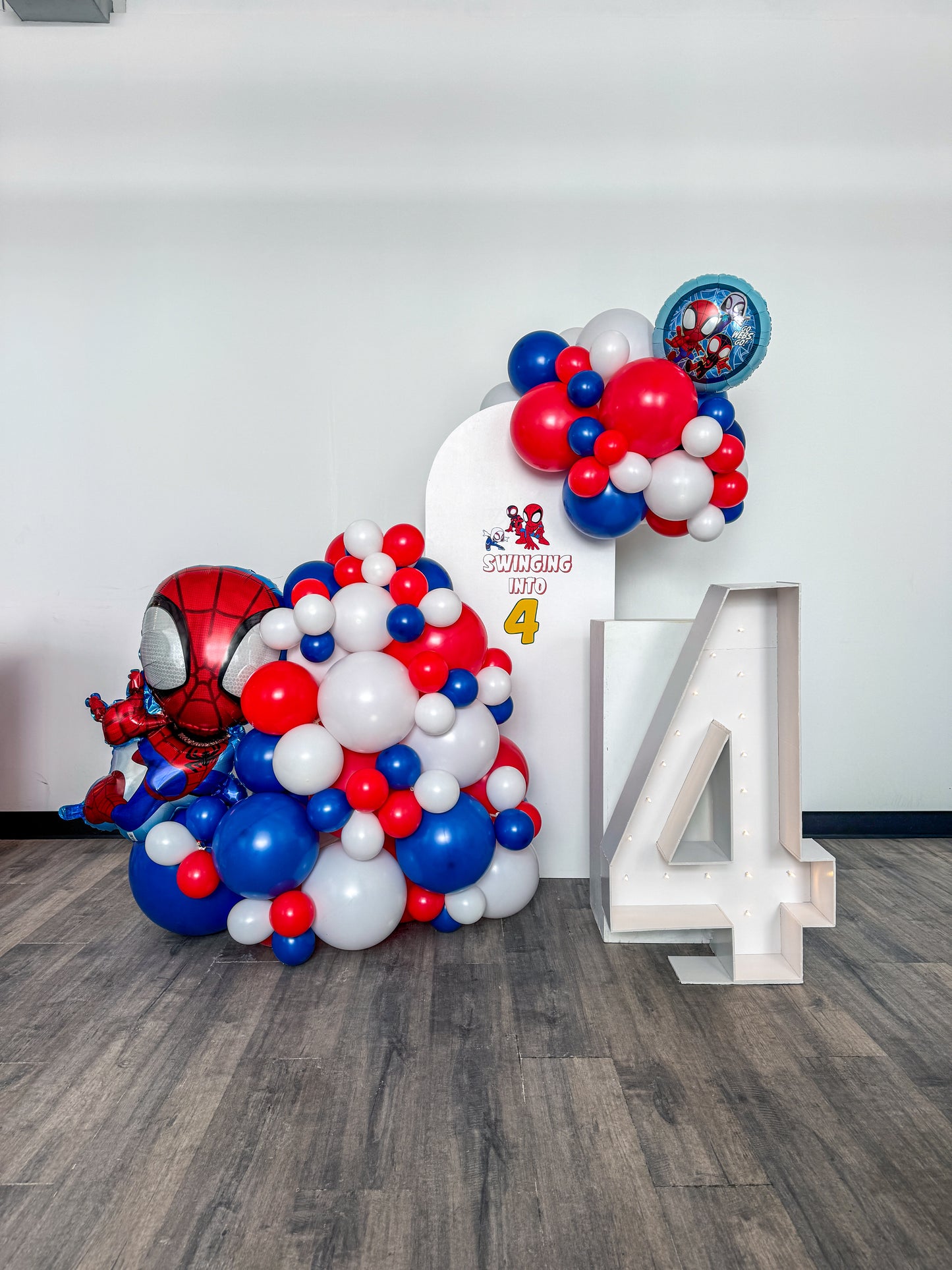 Mini solid backdrop with cake stand and light up number and two themed foils