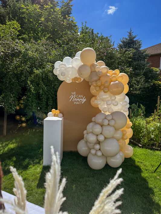 Large solid backdrop with lush side balloons & cake stand