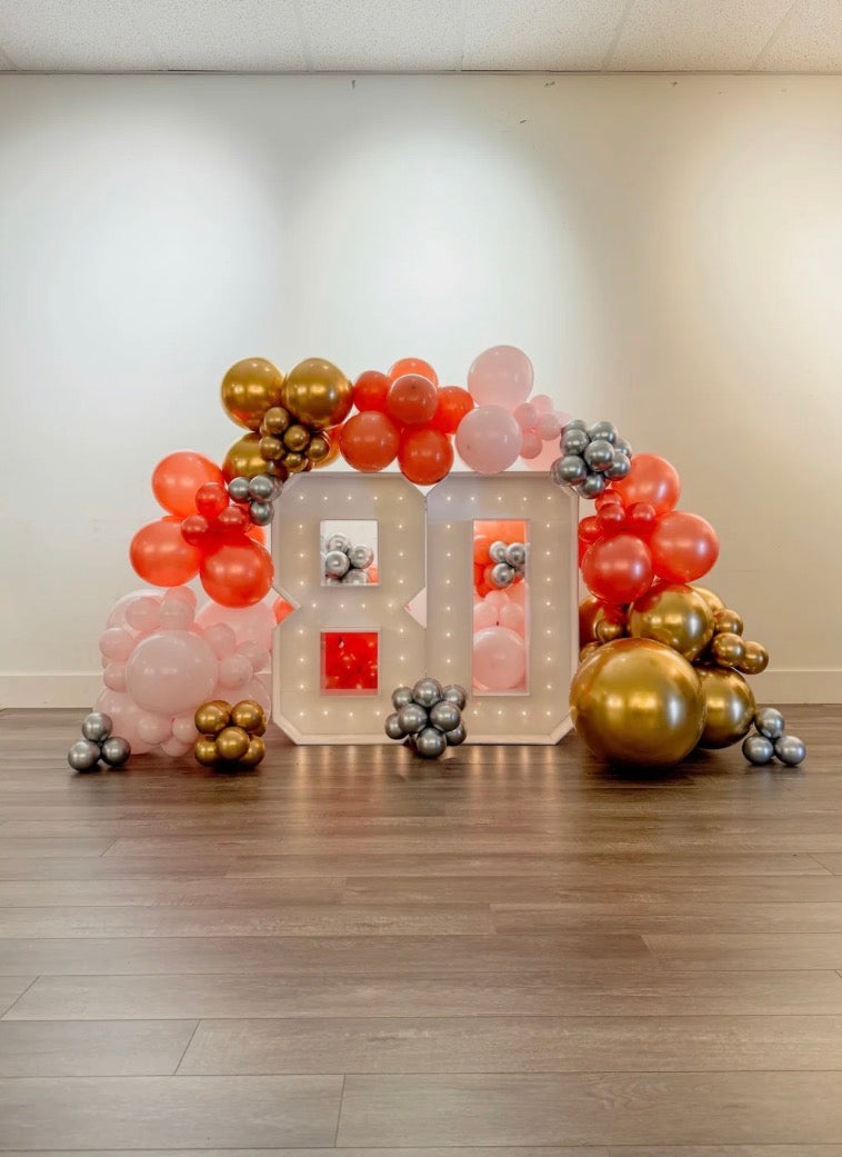 Two light up numbers surrounding balloon garland
